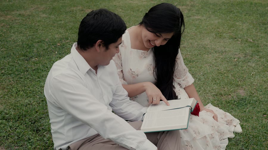Elías y Yenifer leyendo en el pasto