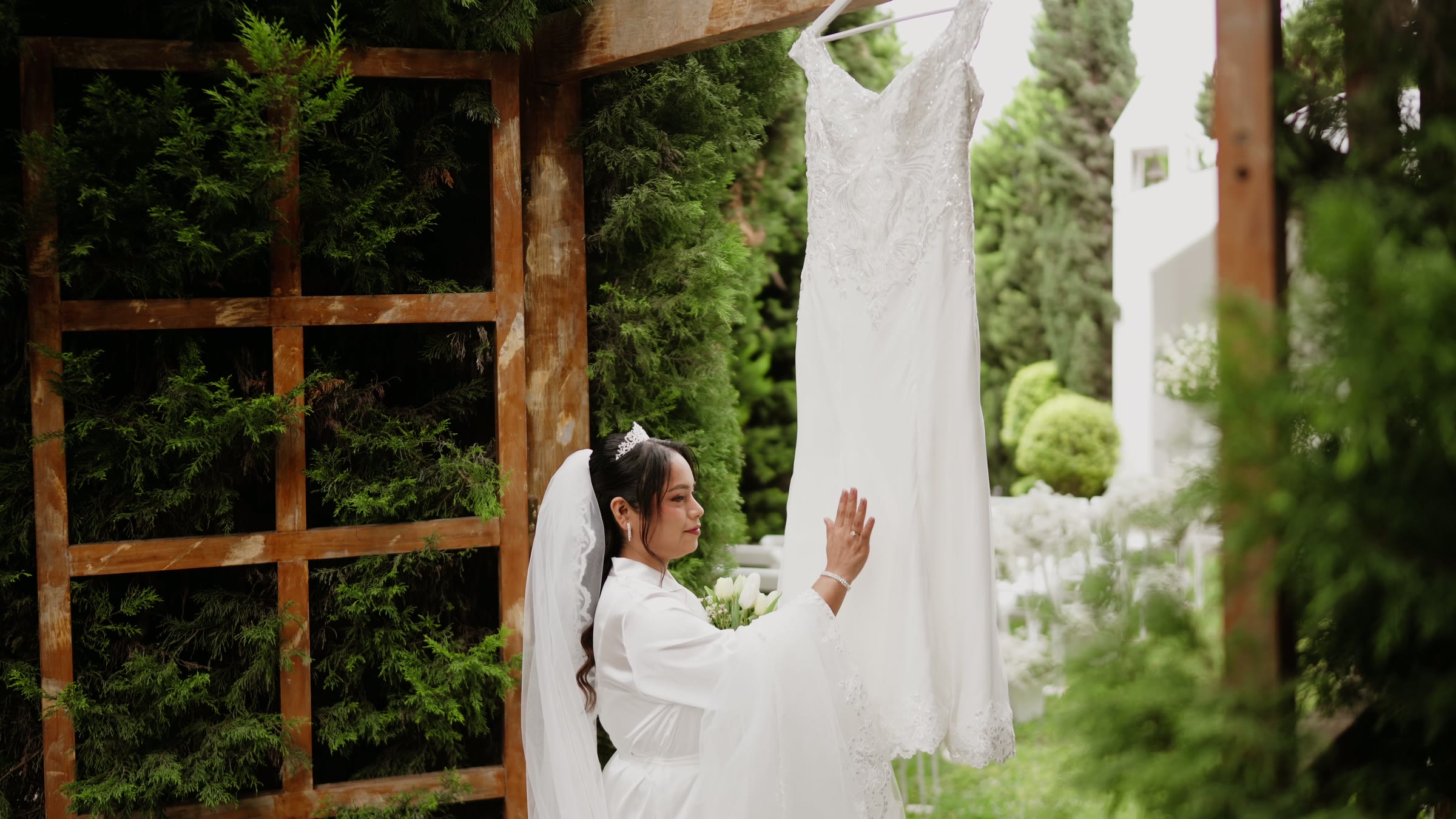 Karla junto a su vestido colgado en el jardín